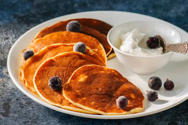 Cottage cheese pancakes with sour cream and berries on a white p — Stock Photo, Image