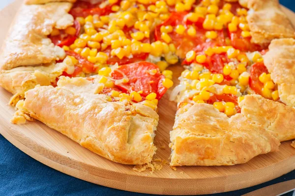 Gros plan de la galette de tomates et de maïs sucré sur une planche de bois . — Photo