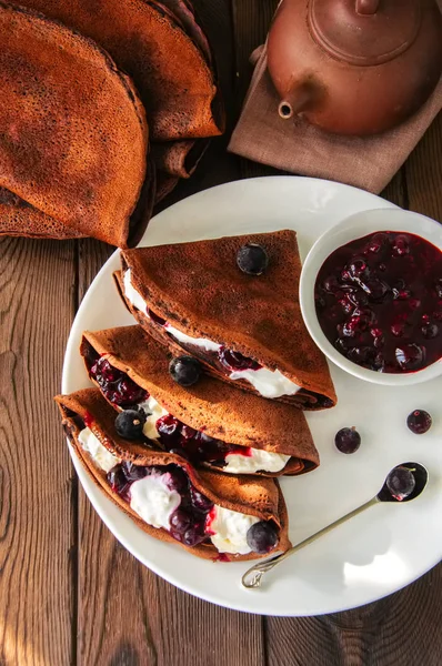 Crêpes au chocolat (blinis) à la crème sure et à la sauce au cassis — Photo