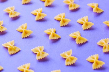 Farfalle makarna mor bir arka plan üzerinde köşegenleri. 