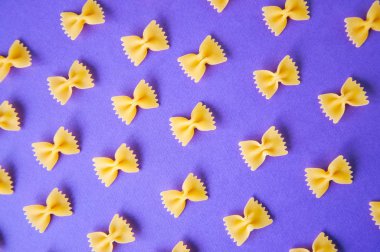 Farfalle makarna mor bir arka plan üzerinde köşegenleri. 