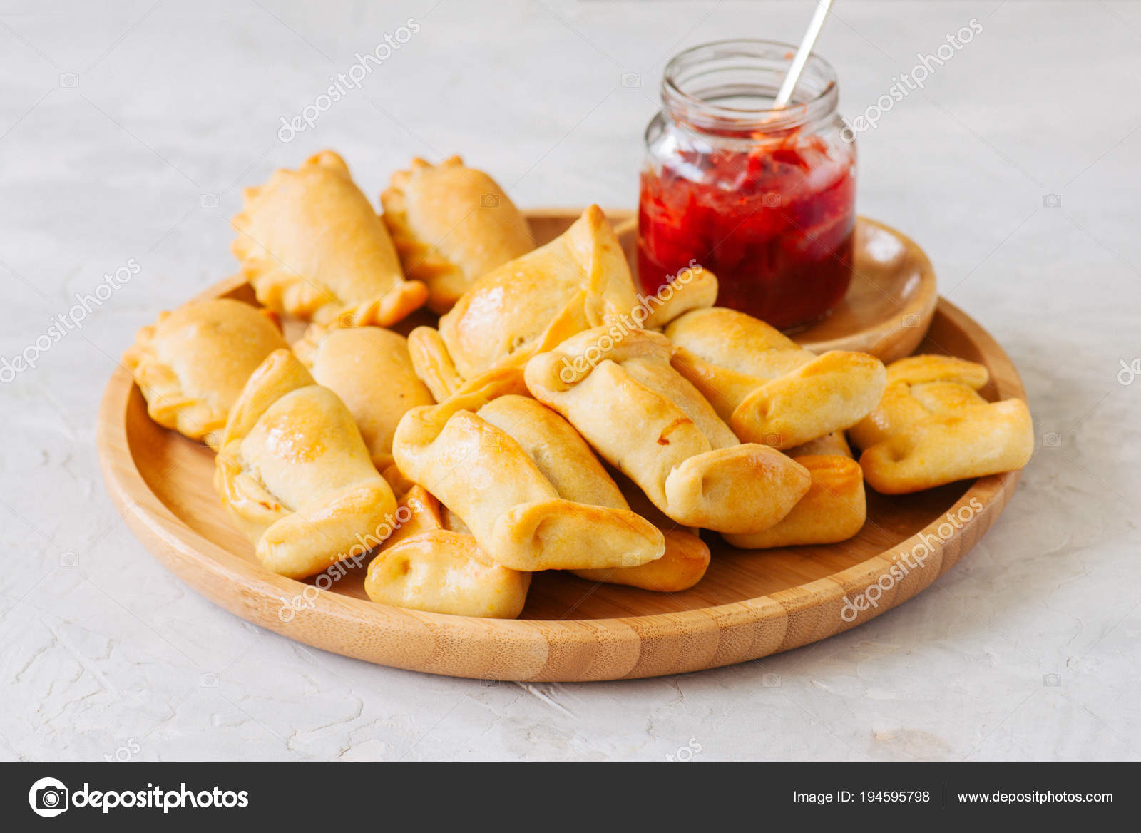 Two types of empanadas on a wooden plate with ketchup Stock Photo by