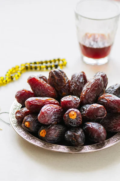 Medjoul - dried dates or kurma in a vintage plate and tea.