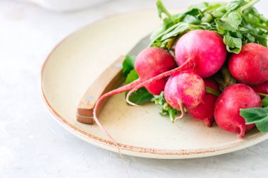 Bir tabak içinde taze olgun turp demet. Beyaz arka plan. Pas