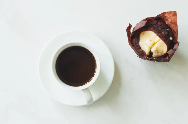 Одна чашка кофе и шоколадный кекс на белом фоне . — стоковое фото