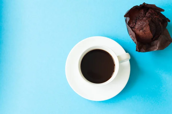 Xícara de café e bolo de chocolate em um fundo azul . — Fotografia de Stock