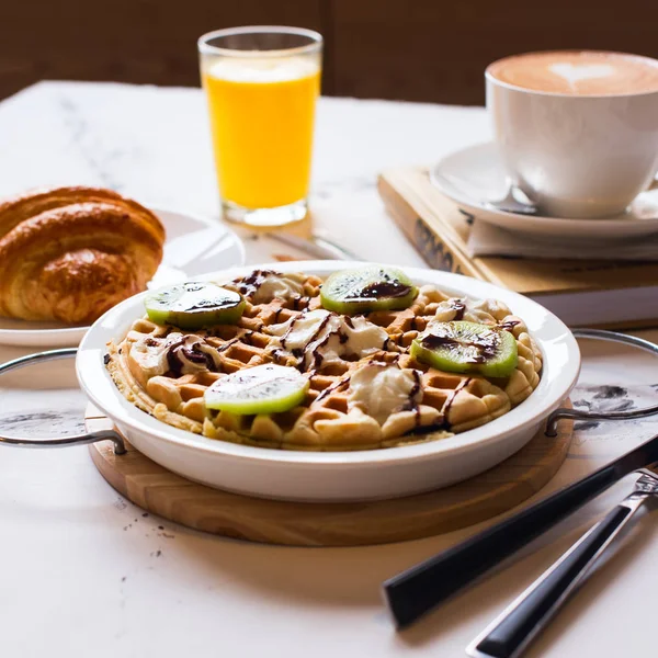 Belga waffles suco e café em um fundo de concreto branco . — Fotografia de Stock