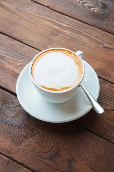 Uma xícara de café em um fundo de madeira . — Fotografia de Stock