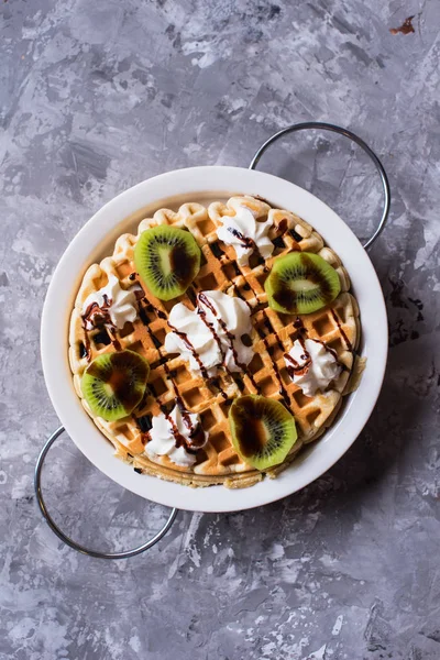 Round belgian waffles in a plate on a gray concrete background. — Stock Photo, Image