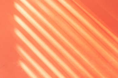 Window blind shadow falling on a bright orange paper