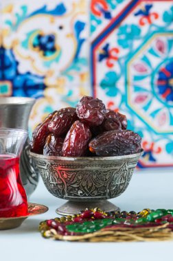 Eski bir kase ve bir bardak Türk çayı içinde Medjoul kurma. Kapat..