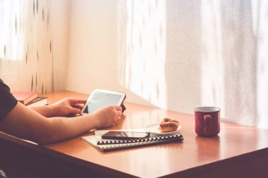Kesilmiş adam evden çalışıyor. Bilgisayar kullanarak ve donut yiyerek. Mesafe çalışması veya çevrimiçi eğitim veya evde kalma kavramı. 