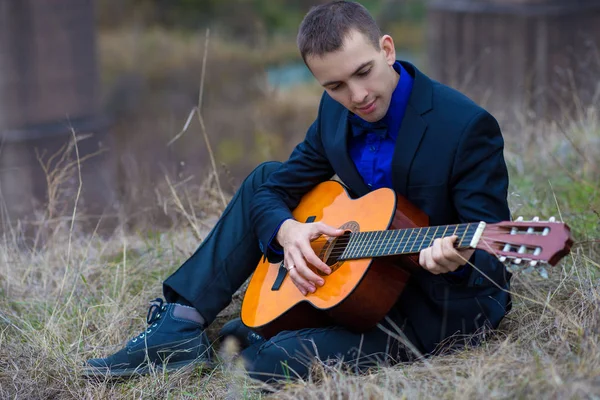 Hombre con una guitarra en el parque — Foto de Stock