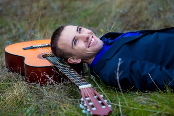 Hombre con una guitarra en el parque — Foto de Stock