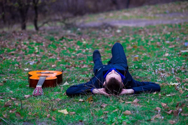 Adam parkta bir gitar ile