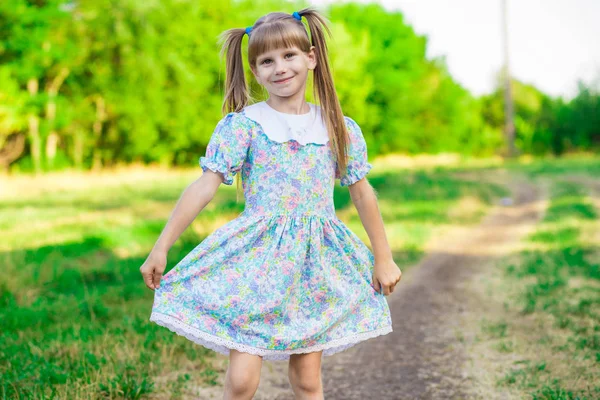 Petite fille joyeuse sur une herbe verte — Photo
