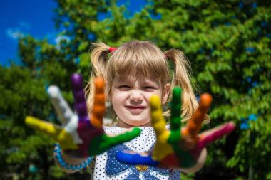 Sevimli kız ellerini gösterilen parlak renklerde boyanmış. El parmak.