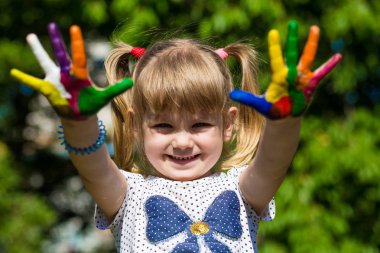 Sevimli kız ellerini gösterilen parlak renklerde boyanmış. El parmak.