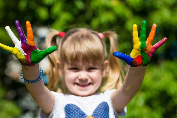 Malá dívka ukazuje malované ruce, zaměření na rukou. Otisky rukou — Stock fotografie