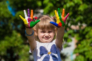 Sevimli kız ellerini gösterilen parlak renklerde boyanmış. El parmak.