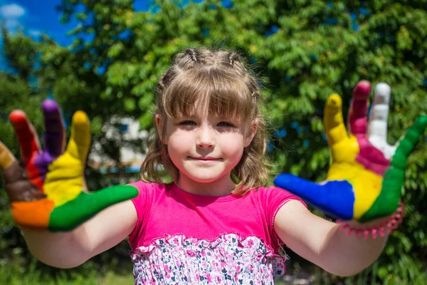 Симпатичная девушка, показывающая свои руки в ярких цветах. Отпечатки рук . — стоковое фото