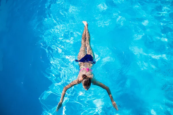 Bovenaanzicht van een meisje duiken in het zwembad — Stockfoto