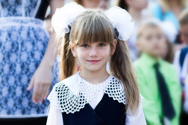 Retrato de uma linda menina em um vestido de escola e em arcos. Primeira série — Fotografia de Stock