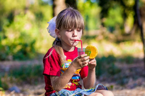 Adorable niña bebiendo limonada con paja —  Fotos de Stock