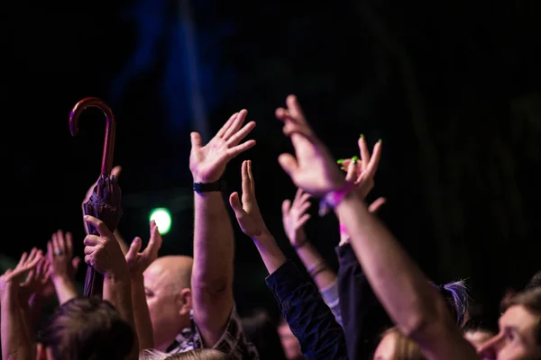 Multitud de personas con las manos en alto durante el concierto de rock sobre fondo oscuro — Foto de Stock