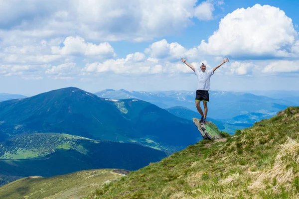 Giovane turista sul bordo della scogliera di montagne con mano in su godere di una splendida vista — Foto Stock