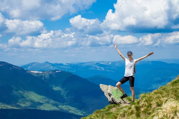 Jovem turista na borda do penhasco de montanhas levantar a mão — Fotografia de Stock