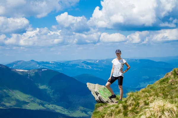 Genç kadın turist dağlar Cliff'in kenarında zevk görünümü