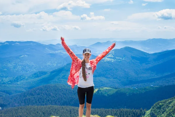 Hiking dağlarda yaz. Doğa eller yukarı dağların tepesinde bir kap içinde uzun saçlı genç turist kız hayran