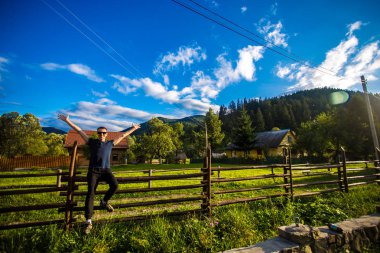 Bir mutlu yakışıklı delikanlı kadar bahçesinde hads bulunan el yapımı ahşap bir çit üzerinde dinlenme güneş gözlüğü