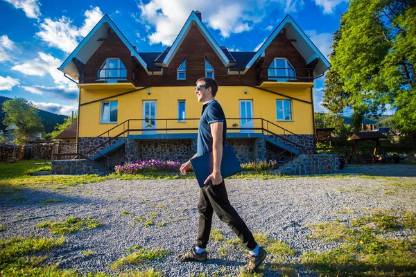 Adam onu yeni ev yakınındaki dizüstü bilgisayar ile ayakta