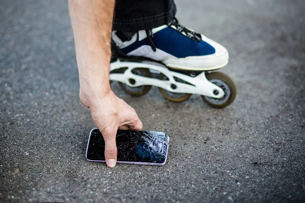Person nimmt kaputtes Smartphone mit geknacktem Bildschirm — Stockfoto