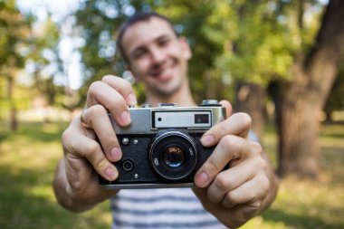 Eller eski vintage kamera tutan genç adam