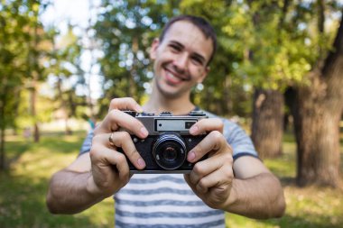 Eller eski vintage kamera tutan genç adam