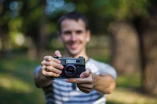 古いビンテージ カメラを手で保持している若い男 — ストック写真