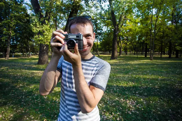 Genç adam retro kamera resim çekme