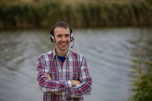 Bir kulaklık daimi giymiş yakışıklı bir gülümseyen müşteri hizmeti operatör portresi 