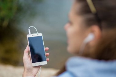 Mükemmel ruhları bir telefon ile genç gülümseyen kadın müzik dinliyor