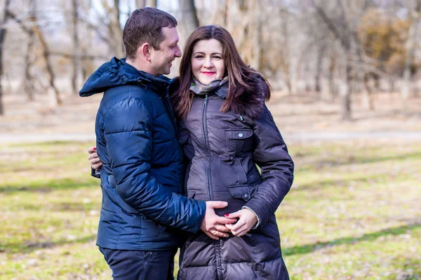 Bela mulher grávida e seu belo marido abraçando a barriga — Fotografia de Stock