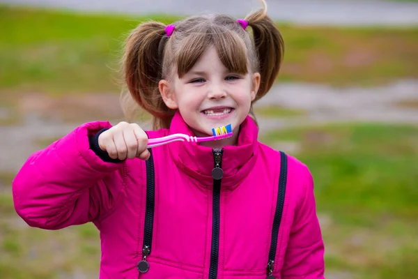 Χαριτωμένο κοριτσάκι που κρατάει μια οδοντόβουρτσα — Φωτογραφία Αρχείου