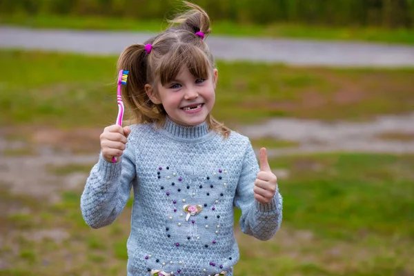 Söt liten flicka som håller en tandborste — Stockfoto
