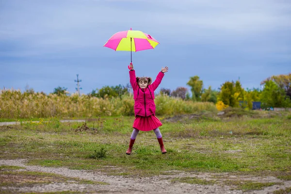 Parapluie coloré fille mignonne sauter drôle au ciel — Photo