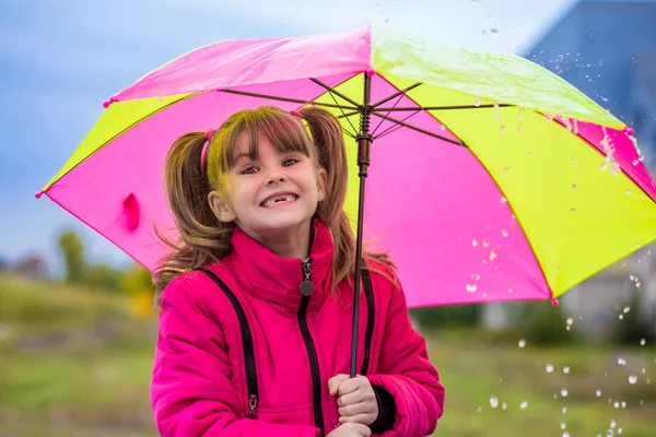 傘を持つ少女は、降雨量を楽しんでいます。 — ストック写真