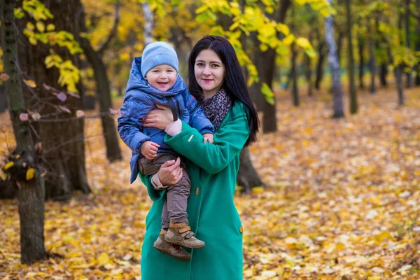 Мать с маленьким сыном играет в осеннем парке — стоковое фото