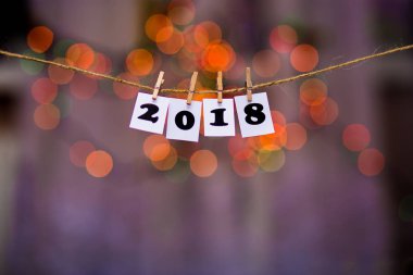 Mutlu yeni yıl 2018 metinle garland bokeh arka plan üzerinde kağıtlara clothespins ile