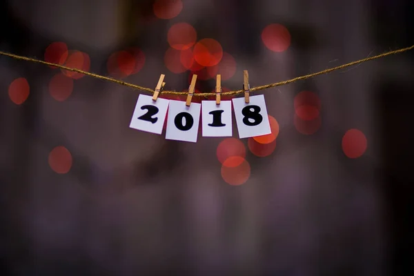 Mutlu yeni yıl 2018 metinle garland bokeh arka plan üzerinde kağıtlara clothespins ile — Stok fotoğraf